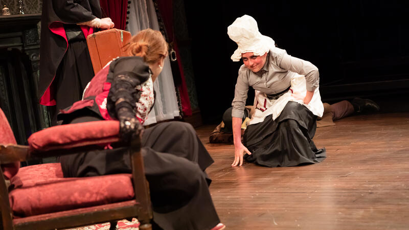 actor playing chef and actor playing lady of the house on wooden flooring