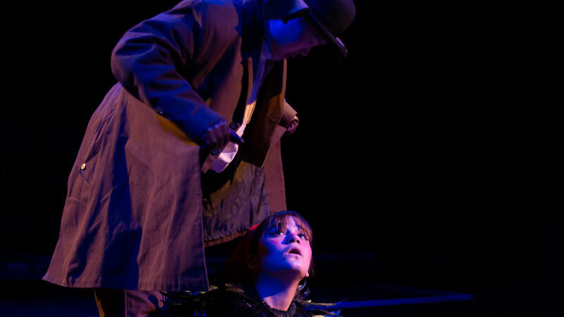 actor as dog with shabby coat standing over actor playing moor hen