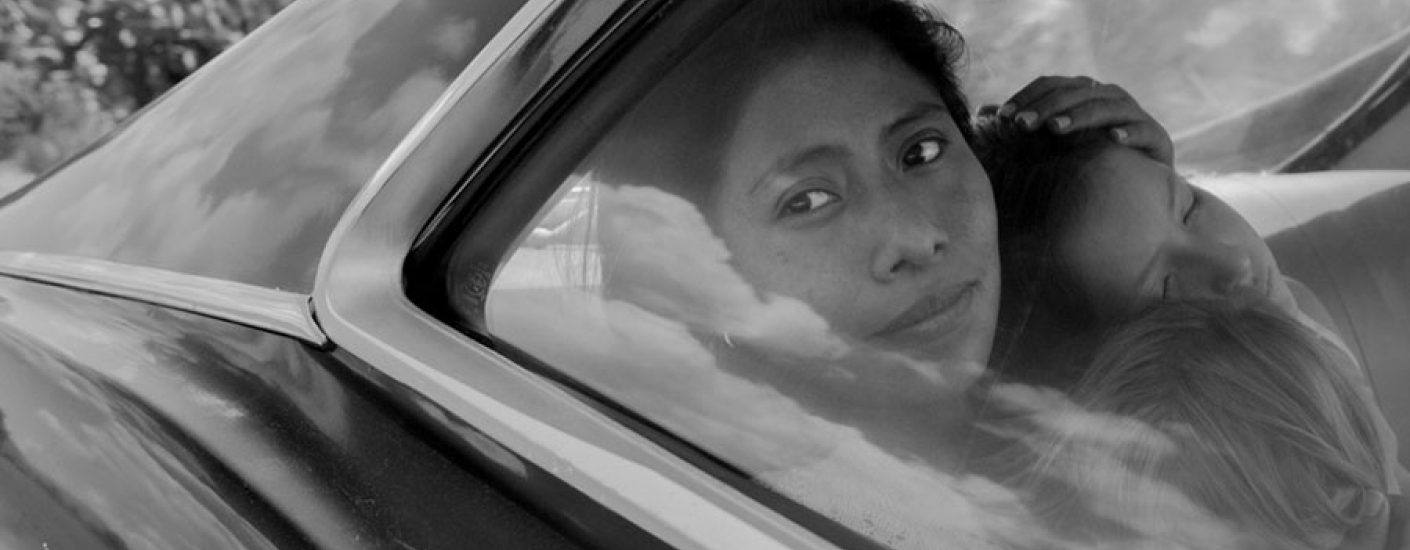 black and white image of a woman in car holding two children