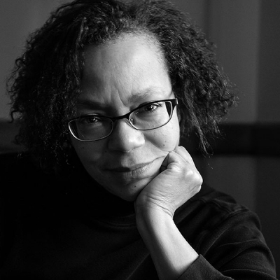 black and white portrait of a woman wearing glasses and looking at camera