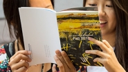 Students read the Fall 2015 Arts Calendar