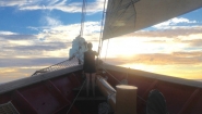 Anthea Fisher ’17 watches the sun set over the Mediterranean Sea from the bow of the SSV Corwith Cramer. 