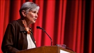 Diane Ravitch ’60 speaking on stage in front of a red curtain