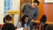 Professor Stanley Chang looks on as a group of students study together. 