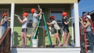 students work on porch of Habitat house