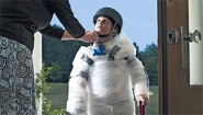 mother strapping helmet on bubble-wrapped kid as he goes out the door