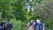 Jane Pauley and Hillary Clinton stroll on footbridge near Lake Waban as crew films