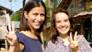 Ami Swanepoele '02 and Victoria Rines '15 make a three-fingered Wellesley W sign