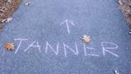 "tanner" and direction arrow chalked on sidewalk