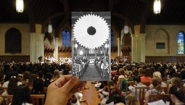 hand holding b&w image of 1970s Flower Sunday in front of full color image of modern flower sunday, both inside Chapel