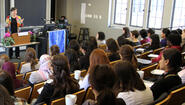 Katherine Marshall lecturing, seen from behind rows of students