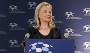 Hillary Clinton at a podium with the Women in Public Service Logo behind her