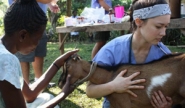 Nikki Wright and Haitian woman examine goat