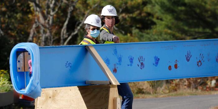 two people in construction gear looking at a construction beam