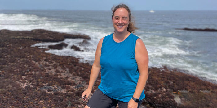 Rebecca Selden standing on a beach with the ocean behind her