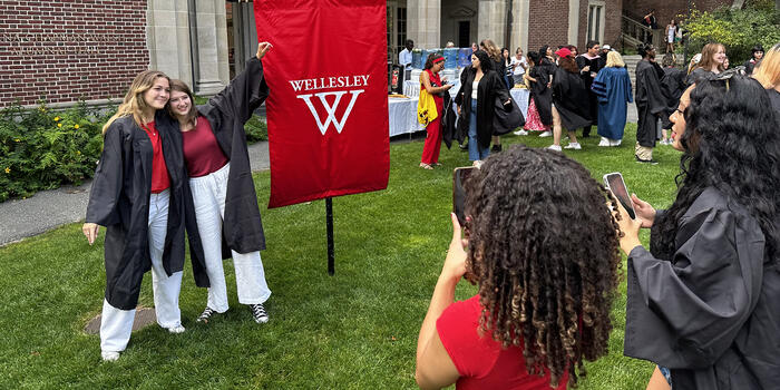 Seniors gather around the 2024 class banner for photos before convocation.