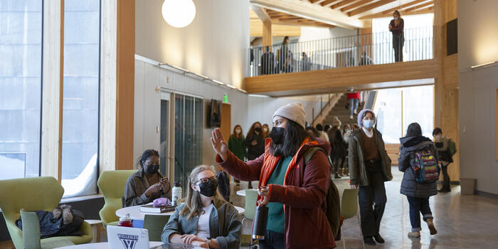 Two students talk to each others with other students walking by in the background in the new science center hub.