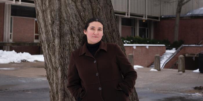 Woman stands outside in front of a tree