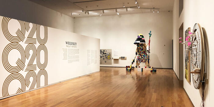 In the Davis Museum. a figure like sculpture stands in a corner.