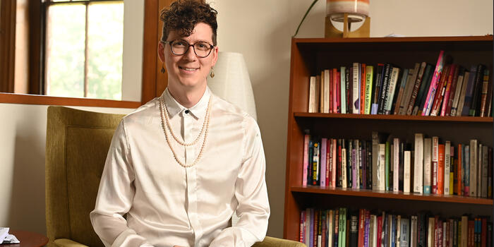 Todd Nordgren sits facing the camera, a bookshelf to his left.