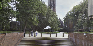 Wellesley College's Galen Stone Tower with the steps of Jewett Hall in the foreground and two students walking.