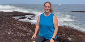 Rebecca Selden standing on a beach with the ocean behind her