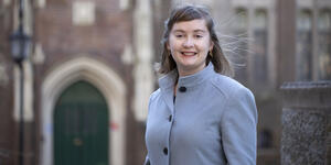 Woman stands outside in front of a building