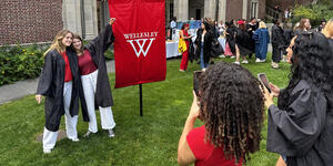Seniors gather around the 2024 class banner for photos before convocation.