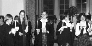 Vintage photo from 1980 showing students holding candles and singing for holidays.