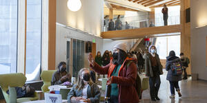 Two students talk to each others with other students walking by in the background in the new science center hub.