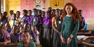 Chantale Zuzi '25 stands with a group of refugee girls at a resettlement camp in Uganda.