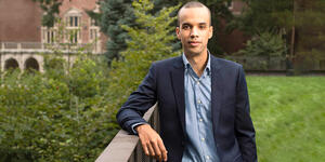 A professor stands on Wellesley's campus looking directly into the camera