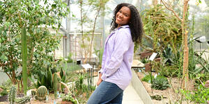 Karissa Coleman poses for a photo surrounded by greenery in Global Flora.