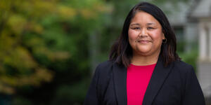 A portrait of Peaches Valdes. She wears pink top under a dark blazer.