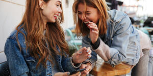 Two young women share a laugh together.