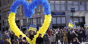Demonstrators display a heart made of balloons featuring colors from the Ukrainian flag as they march during a rally in support 