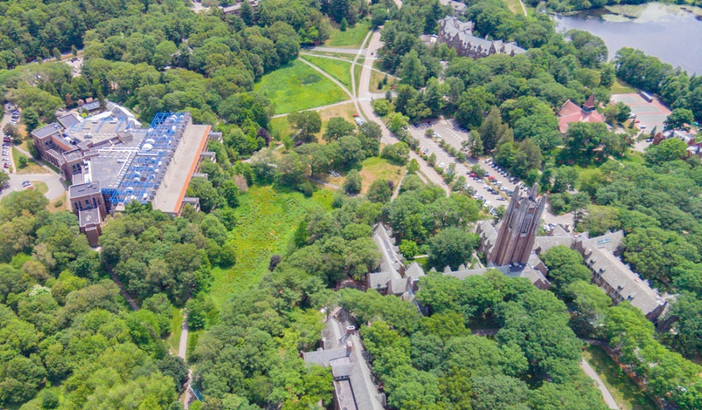 An aerial view of Wellesley's campus featuring lake waban and green hall. 