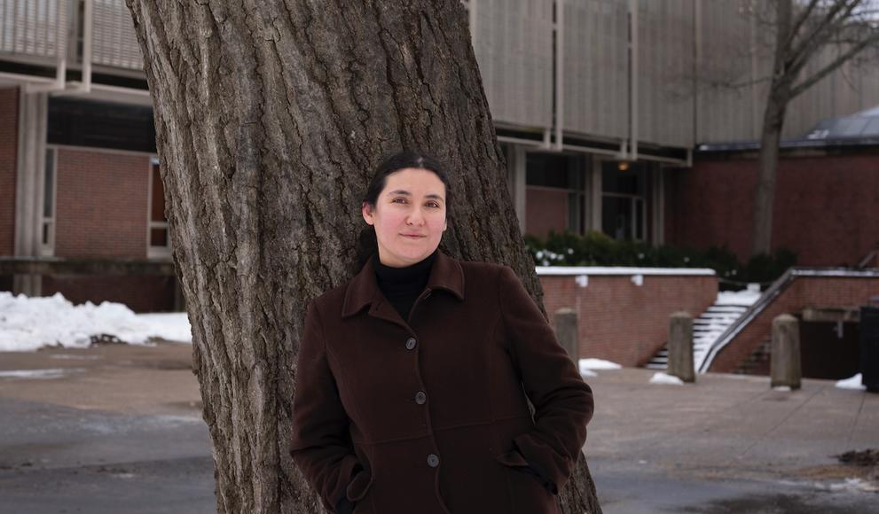 Woman stands outside in front of a tree