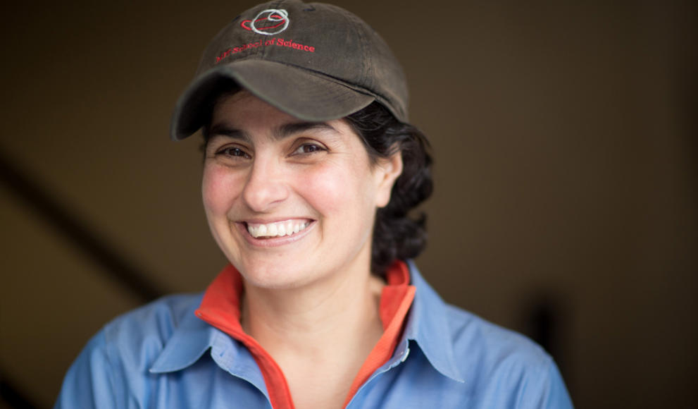 Portrait of astrophysicist Nergis Mavalvala ’90. She is smiling and wearing a baseball hat.