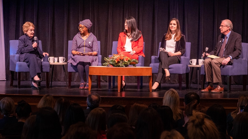 A panel of students sit with Madeleine Albright on stage.