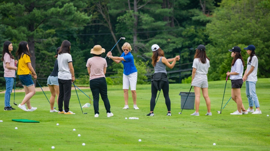 Leslie Andrews ’82, director of the Nehoiden Golf Club, leads a golf lesson with undergraduate students in a summer program.