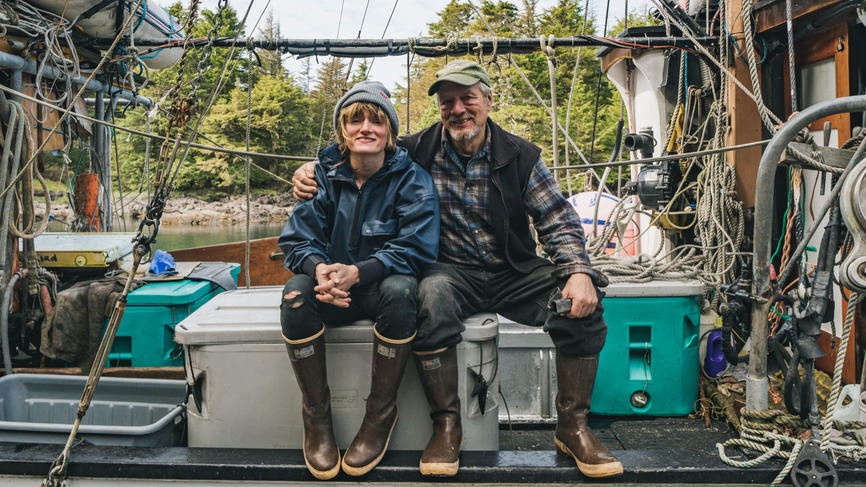 Elsa Sebastian and her father sitting on a fishing boat and smiling