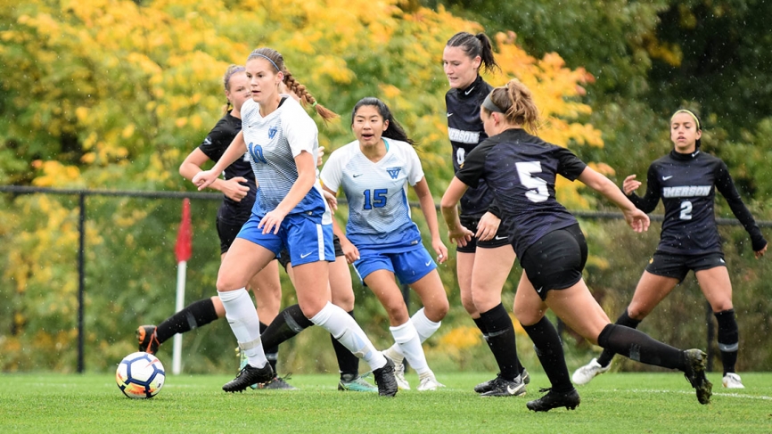 A Wellesley soccer player breaks from the pack with the ball.