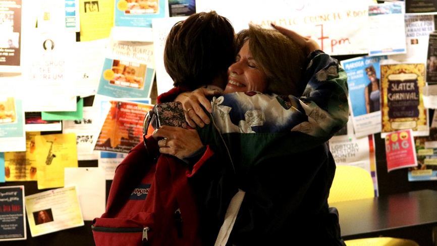 A student hugs her mother