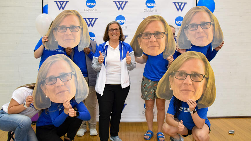 Bridget stands with a half dozen individuals who hold large cutouts of her face in front of their own 