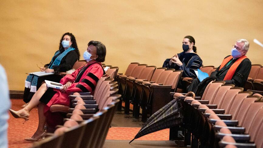 group shot of people sitting socially distanced in an auditorium
