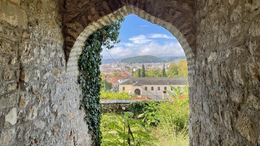 A view overlooking a Greek town taken from inside a stone building.