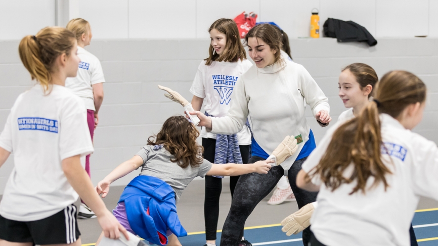 young girls practice fencing technique with gloves