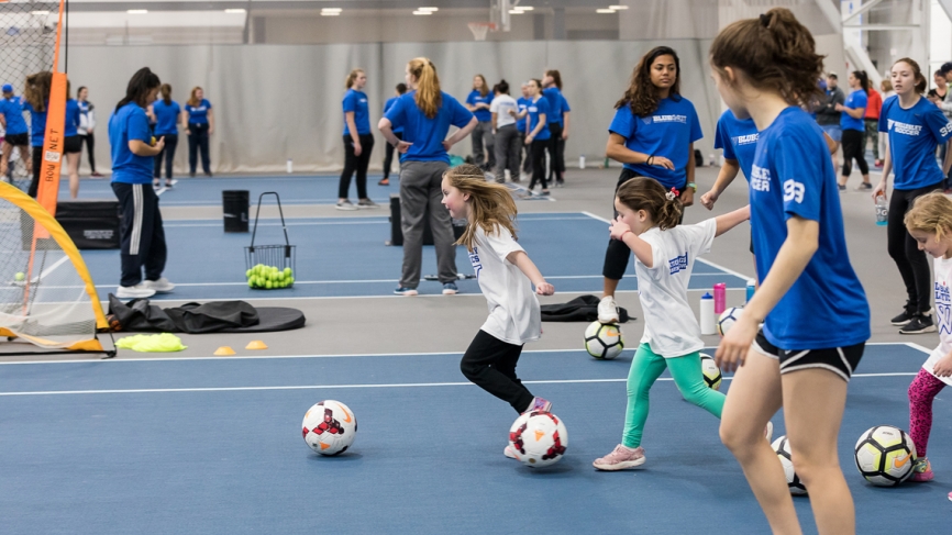 Young girls dribble soccer balls 