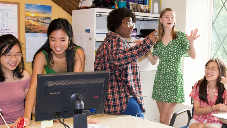 Five students work in an office, preparing for orientation 2019. 